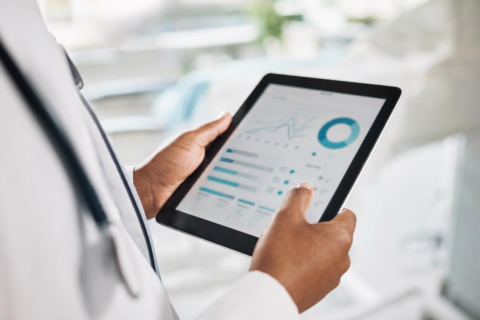 A clinician reviewing healthcare data on a tablet